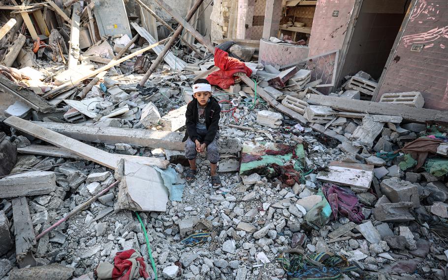 An injured Palestinian child sits on rubble after the Israeli bombing of Rafah in the southern Gaza Strip on Jan. 18, 2024.
