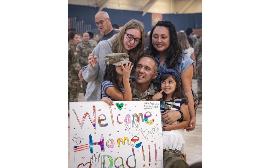 Manuel Garcia, a 4th Infantry Division operations NCO, poses with his family after the Division uncasing ceremony in the Special Events Center on Fort Carson, Colorado, Sept. 13, 2023.
