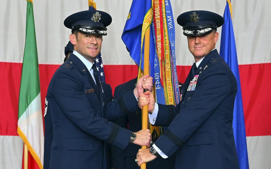 Clark hands the guidon to Moga.