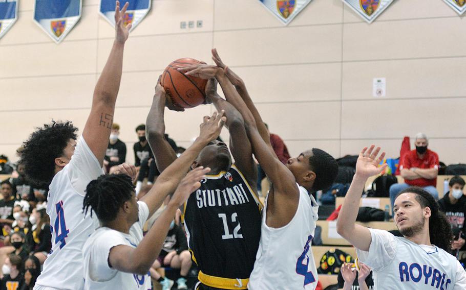 Surrounded by almost the whole Ramstein Royals team, Stuttgart’s Jaures Segning tries to take a shot in opening day action at the DODEA-Europe Division I championships in Ramstein, Germany, Feb. 23, 2022. Ramstein won the game 54-37.