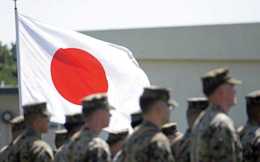 A Japanese flag waves in the breeze as Marines attend a ceremony at Camp Courtney’s parade grounds on Okinawa, March 7, 2023.