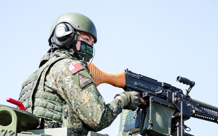 A member of Taiwan's armed forces holds a weapon atop a CM-11 Brave Tiger main battle tank during a military exercise in Hukou, Hsinchu County, Taiwan, on Jan. 19, 2021.