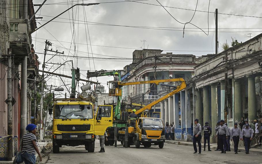 Members of a Cuban electric company repair power lines in El Cerro, Cuba, on Thursday, Sept. 29, 2022, in the aftermath of Hurricane Ian.