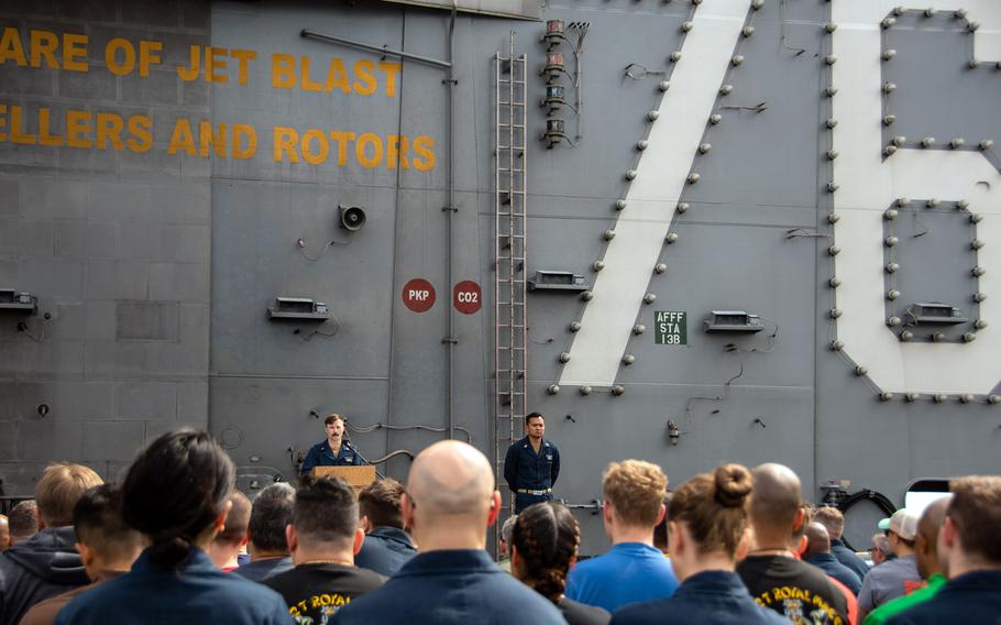The USS Ronald Reagan's crew gathers on the flight deck to celebrate the 20th anniversary of the ship's commissioning while on patrol in the Indian Ocean, July 30, 2023.