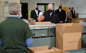 President Joe Biden packs produce while volunteering at hunger relief organization Philabundance, Sunday, Jan. 16, 2022, in Philadelphia. (AP Photo/Patrick Semansky)