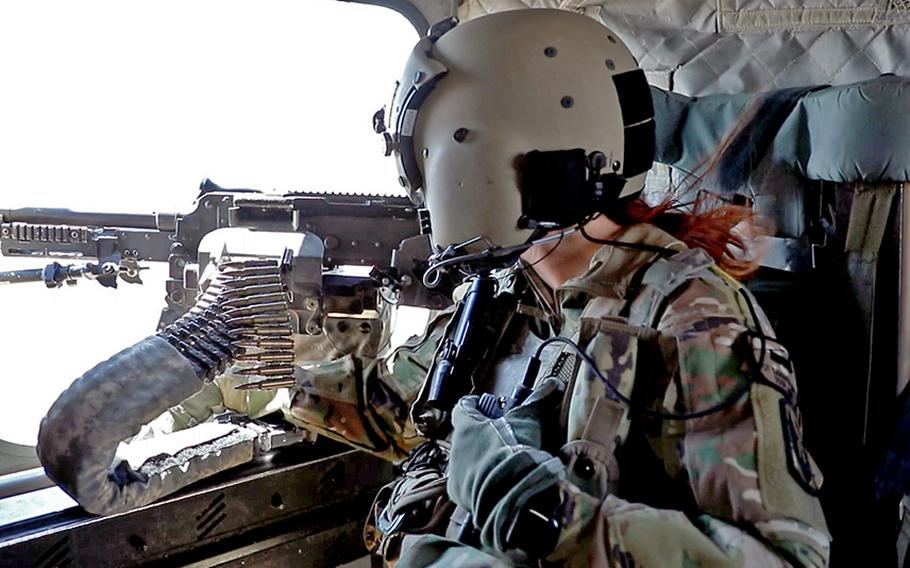 Sgt. Samantha Harvey, a CH-47 Chinook helicopter crew member with the 3rd General Support Aviation Battalion, 126th Aviation Regiment of the Massachusetts Army National Guard, scans outside the helicopter while conducting operations near al Asad Air Base, Iraq, on Aug. 23, 2023. 