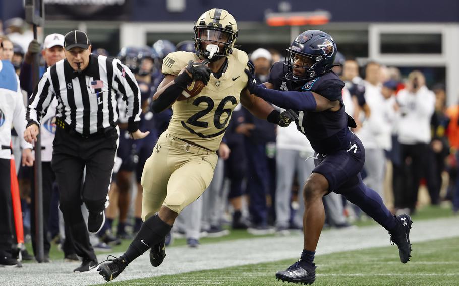 Army’s Kanye Udoh runs past Navy’s Mbiti Williams Jr. during the first quarter of an NCAA football game at Gillette Stadium Saturday, Dec. 9, 2023, in Foxborough, Mass.