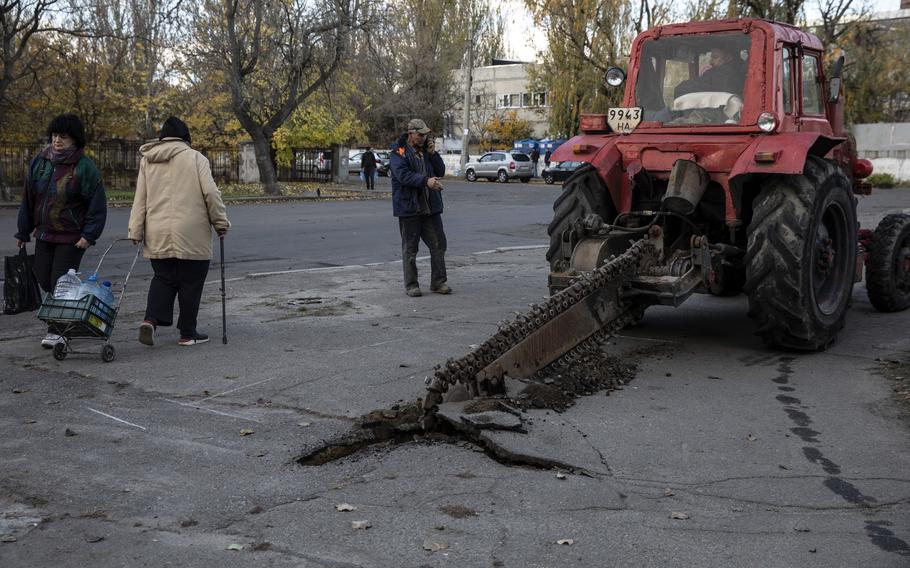 Workers try to repair water lines under a street in Mykolaiv in southern Ukraine on Monday. Many homes in the city have been without clean drinking water since last April. 