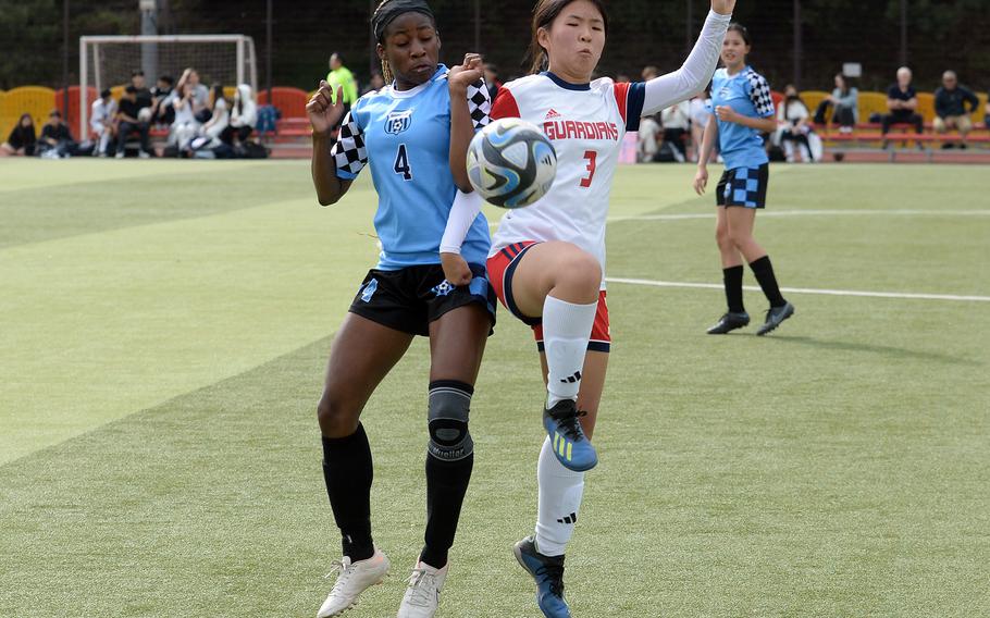 Osan's Tatiana Lunn and Yongsan International-Seoul's Zoe Chung try to play the ball during Friday's Korea girls soccer match. The Guardians won 2-1.