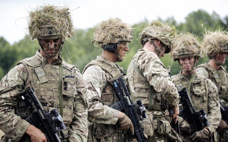 Uniformed cadets line up to clear their rifles.