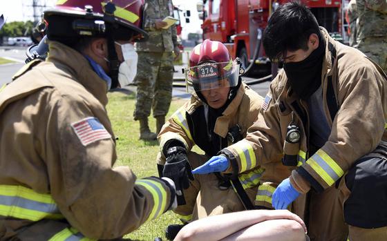 Firefighters attend to a simulated casualty during a major accident response exercise at Yokota Air Base, Japan, May 11, 2022.