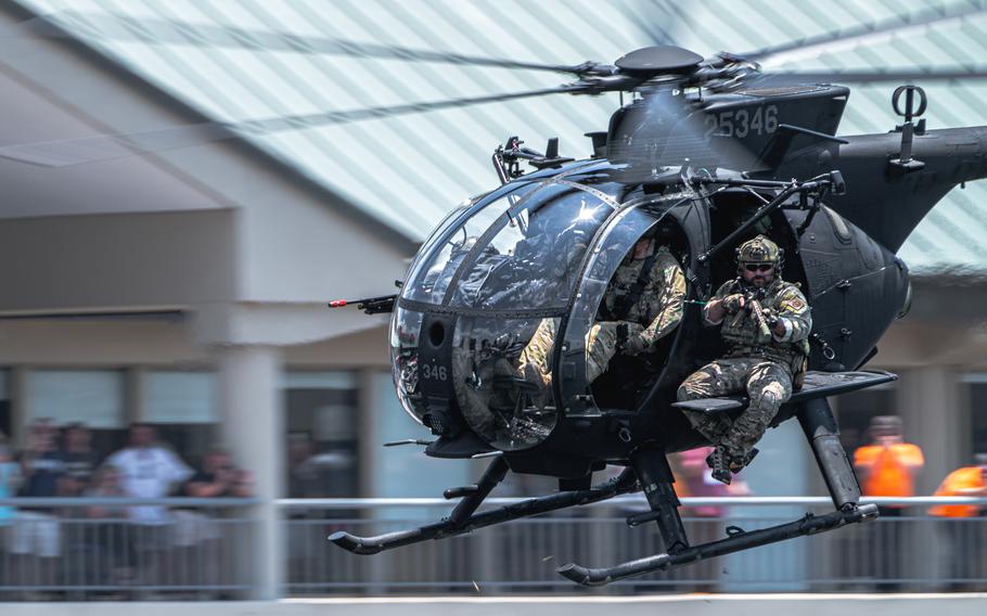 Members assigned to U.S. Special Operations Command fire blank rounds from a helicopter during a Special Operations Forces (SOF) demonstration in downtown Tampa, Fla., May 18, 2022.