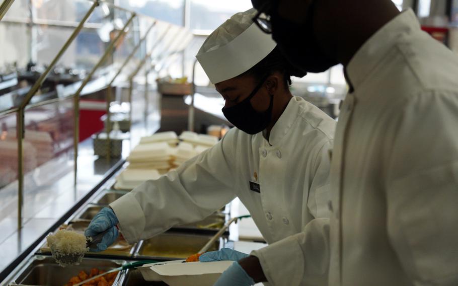 Army culinary specialist Kimyatte Small wears a mask while preparing a meal at Camp Zama, Japan, Feb. 3, 2022. 