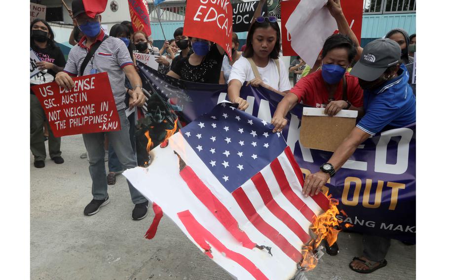 Protesters display placards and burn a mock US  flag to protest the visit of U.S. Defense Secretary Lloyd Austin to the Philippines Thursday, Feb. 2, 2023, at Camp Aguinaldo in suburban Quezon city northeast of the capital Manila. Austin’s visit yielded U.S. access to at least four Philippines military bases through the Enhanced Defense Cooperation Agreement following his meetings with President Ferdinand Marcos Jr., acting Defense Chief Carlito Galvez and Armed Forces Chief Gen. Andres Centino.