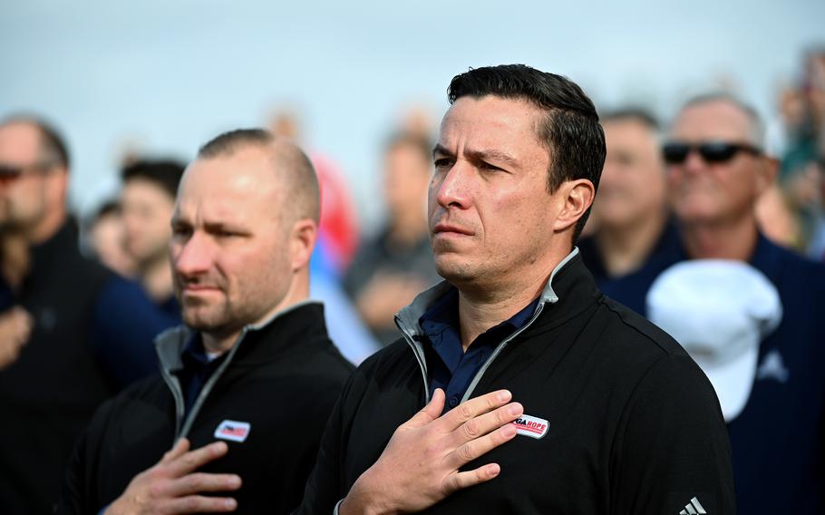 Christopher Cordova, center right, and other veterans stand at attention as the national anthem is sung at the PGA Hope event at Congressional Country Club in Bethesda, Md., on Monday, Oct. 17, 2022.