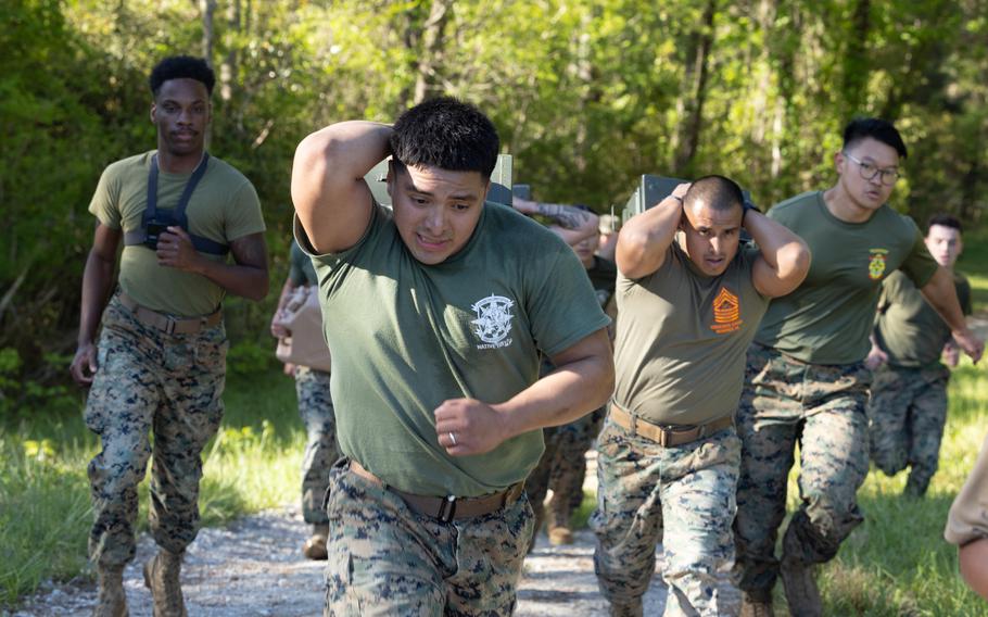A Marine carries an ammo can during a physical training event