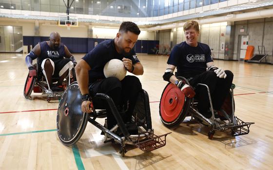 Kyle Hansel, center, from Pacifica, controls the ball against Chet Miller, right, from Santa Cruz, with the help of Desmond Wilson, from Vallejo, during rugby practice at the Palo Alto Veterans Association Medical Center in Palo Alto, Calif., on Monday, Oct. 16, 2023. Wish Book for BAWPVA, Bay Area and Western Chapter Paralyzed Veterans of America. (Nhat V. Meyer/Bay Area News Group)
