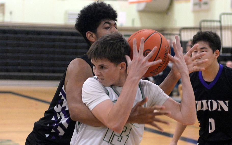 Kubasaki's Lucas Andrews and Zion's Armani Watkins tangle for the ball during Tuesday's Okinawa boys basketball game. The Dragons won 86-42.