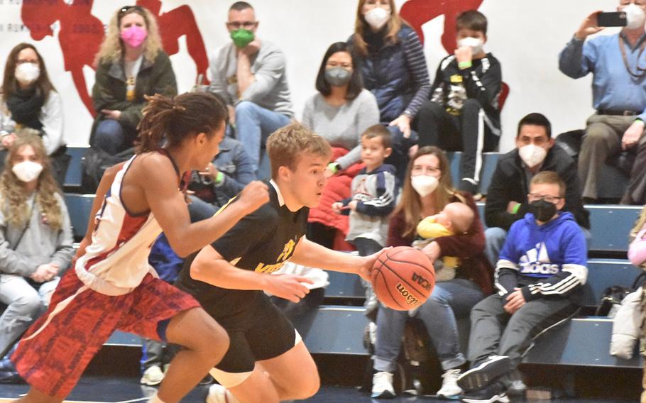 Vicenza’s Will Besterman dribbles up court while pressured by Aviano’s Deon Walker in the Saints’ 51-48 victory over the Cougars on Friday, Feb. 4, 2022.