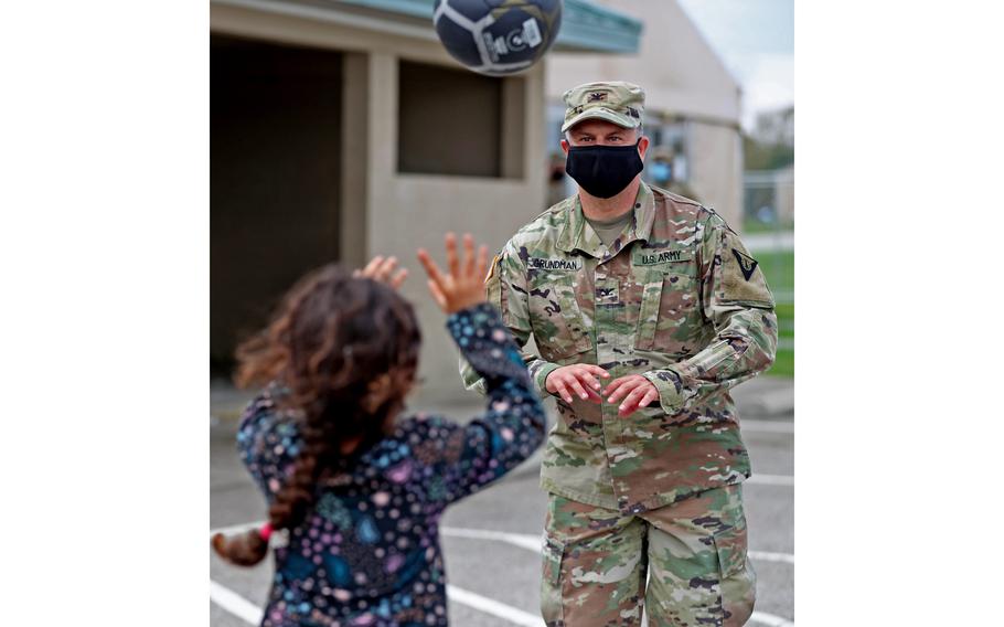 Children play volleyball with soldiers and others outside an Operation Allies Welcome community building Thursday, Oct. 14, 2021, at Camp Atterbury in Edinburgh, Ind.
