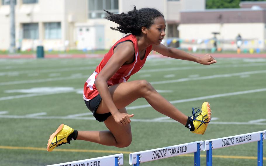 Kinnick's Nina Gaudin leaps the hurdles in the 300-meter hurdle preliminaries.