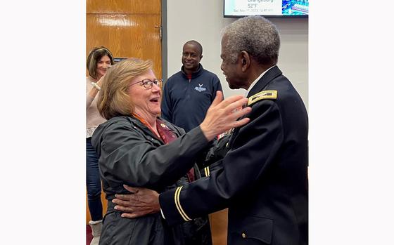 Kris Feeney and Col. Ned Felder hug at their first meeting, with his oldest son in the background. 