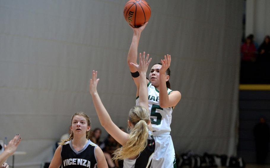 Naples’ JuJu Martinez shoots over Vicenza’s Addison Kropp in a Division II semifinal at the DODEA-Europe basketball championships in Ramstein, Germany, Feb. 17, 2023. The Wildcats beat the Cougars 46-39. At left is Mackenzie Blue.