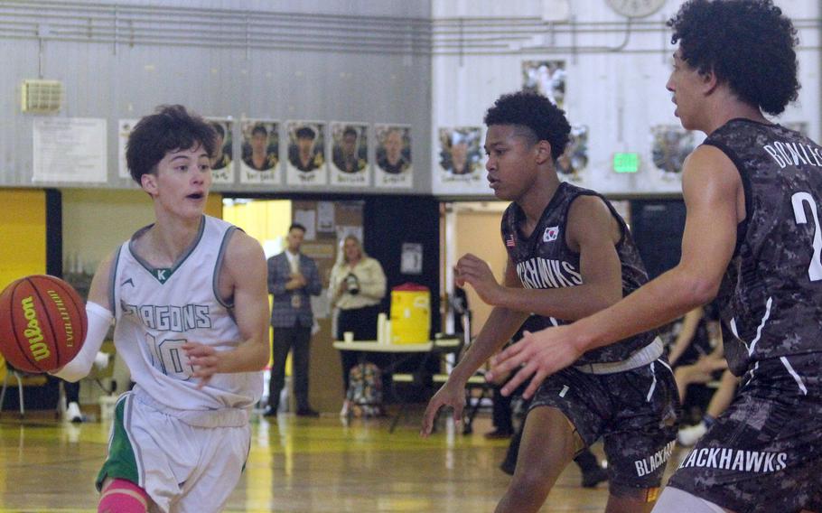 Kubasaki's Troy Harris dribbles against Humphreys defenders during Monday's Far East Boys Division I pool-play game, won by the Dragons 59-43.