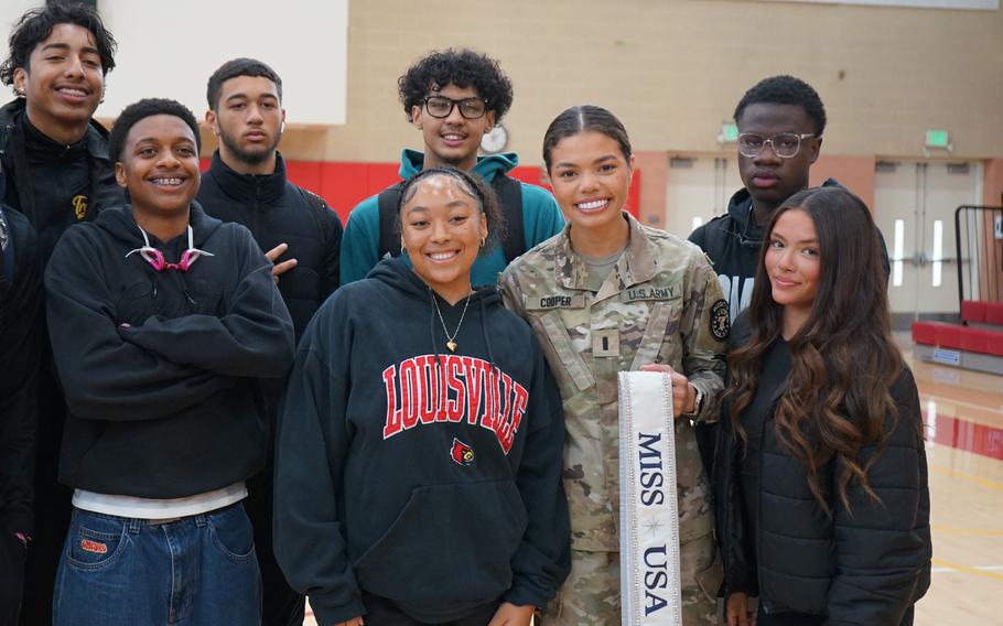 A soldier poses for a photo with a group of students