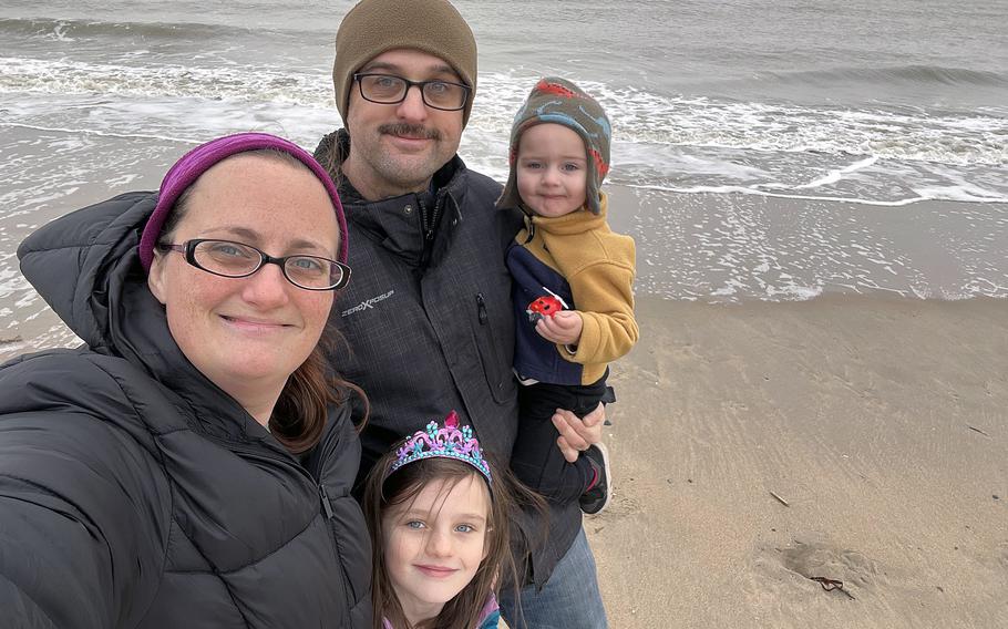 The Anders family poses for a photo on a beach. 