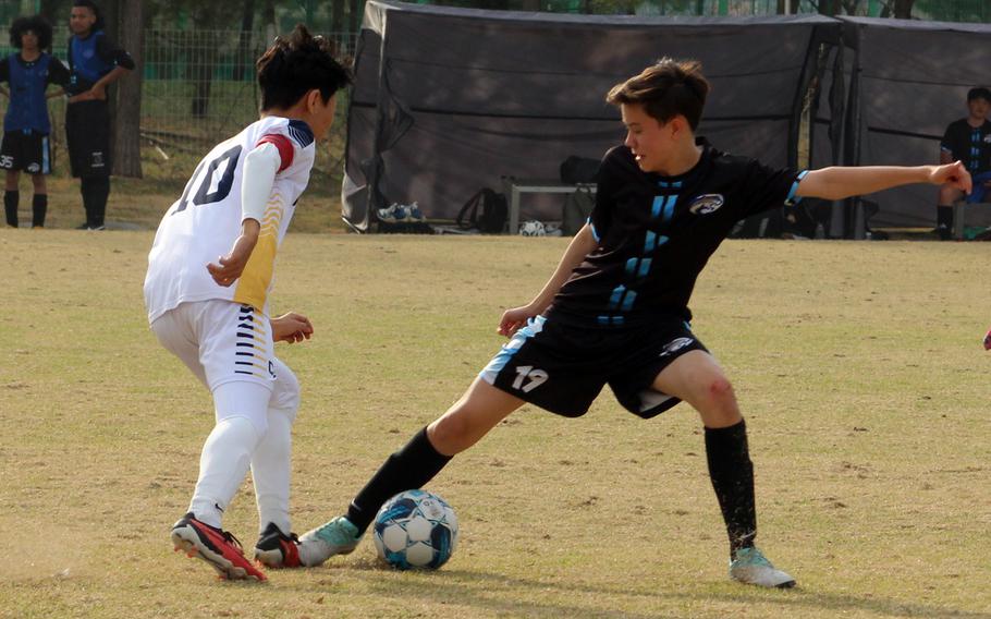 Osan's Aiden Machmer battles for the ball with Cheongna Dalton's Doyoung Yoon during Wednesday's Korea boys soccer match. The Cougars lost 8-0.