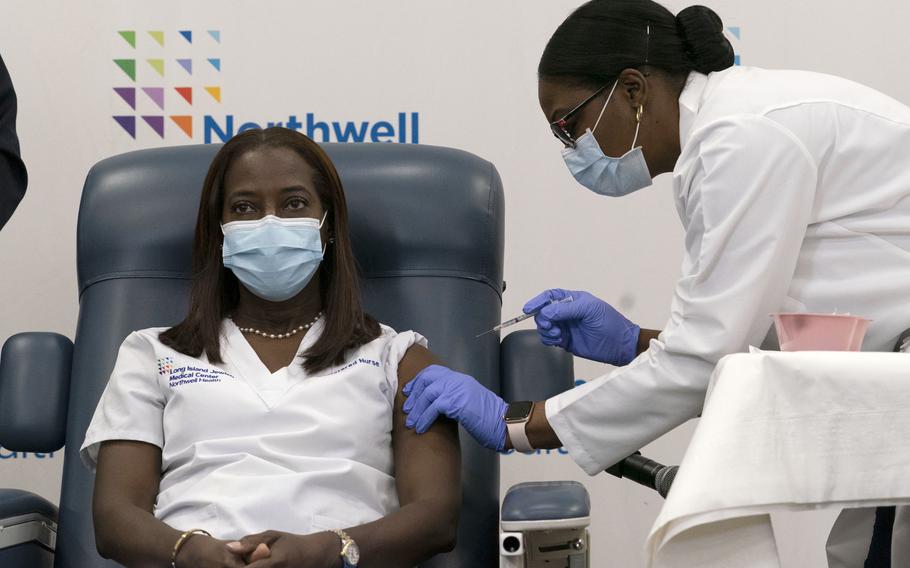 Sandra Lindsay, left, a nurse at Long Island Jewish Medical Center, is inoculated with the Pfizer-BioNTech COVID-19 vaccine by Dr. Michelle Chester, Monday, Dec. 14, 2020, in the Queens borough of New York. (AP Photo/Mark Lennihan, Pool)