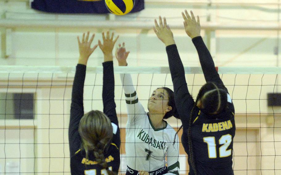 Kubasaki’s Sophia Grubbs spikes thorugh the double block of Kadena’s Presley Pearce and Malana Williams during Thursday’s Okinawa volleyball match. 