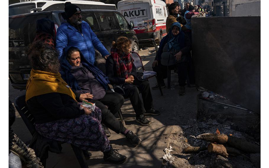 The family of Sakine Demir wait at the site of Demir’s collapsed building in Islahiye, Turkey, on Feb. 12, 2023. Demir and her youngest daughter, Semra, have been missing since earthquakes hit Turkey and Syria on Feb. 6.