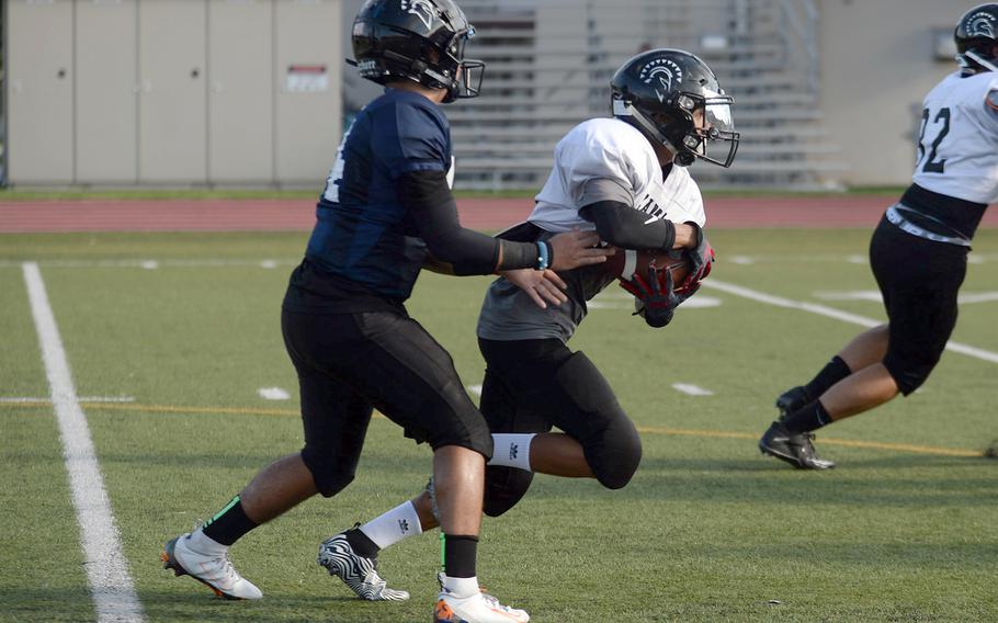 Zama junior running back Hiroki Davis takes a handoff from junior quarterback Kai Kuroda.