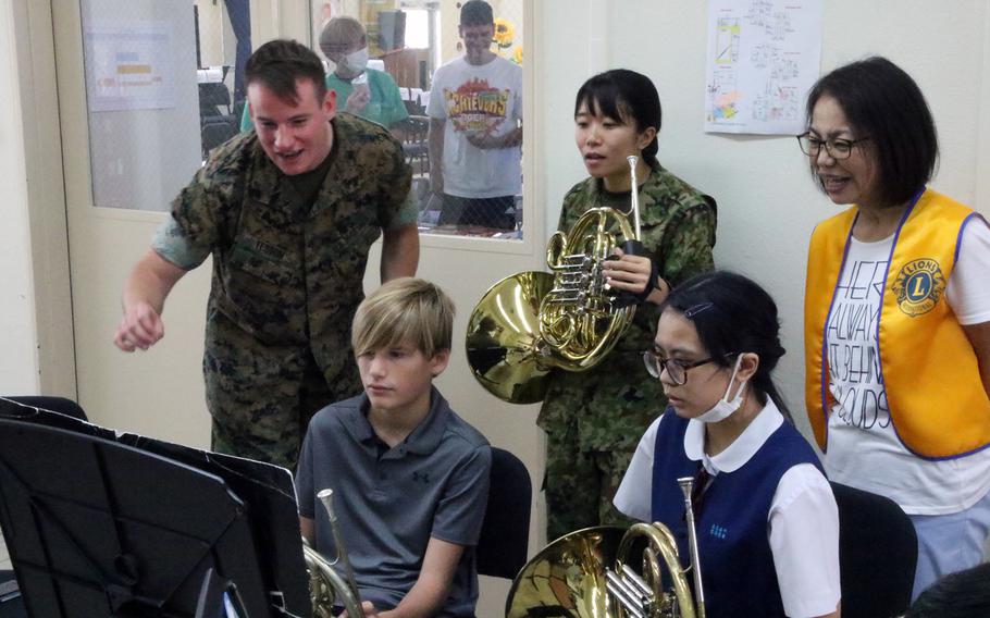 Members of the III Marine Expeditionary Force and Japan Ground Self-Defense Force 15th Brigade bands offer pointers during the Friendship Music Festival at Camp Lester, Okinawa, May 20, 2023.