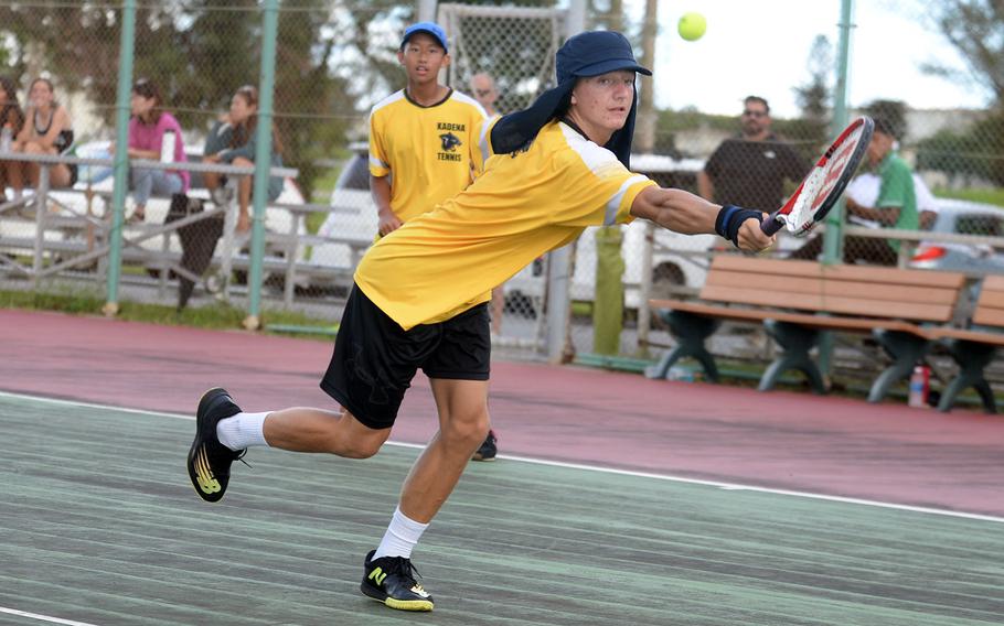 Kadena's Micah Berry lunges for a backhand volley as partner Kaedon Truong watches during Thursday's Okinawa tennis doubles matches. Berry and Truong beat Kubasaki's Max Lundberg and Luka Koja 6-4.