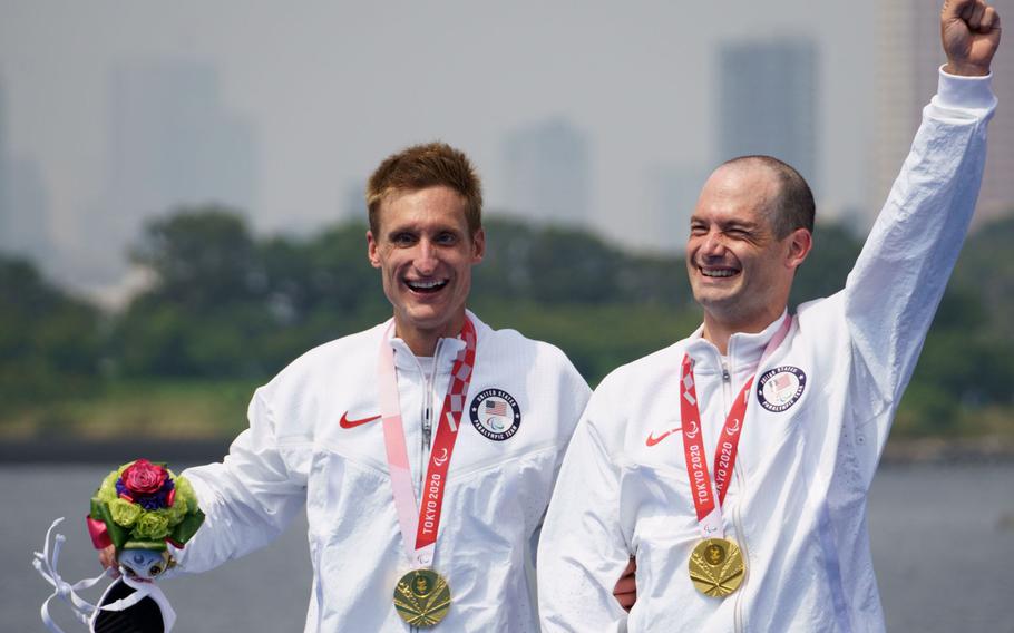 Navy veteran Bradley Snyder, left, who lost his sight during an Afghanistan blast in 2011, and Greg Billington ceberate after winning a gold medal in the Paralympic triathlon at Odaiba Marine Park, Tokyo, Saturday, Aug. 28, 2021.