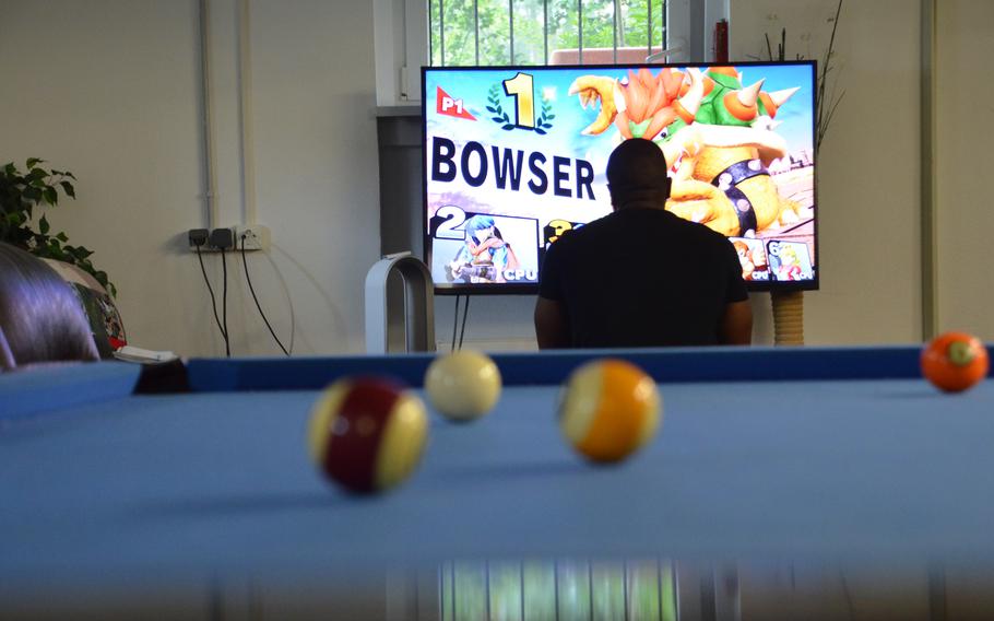 A service member returning from an overseas deployment plays a video game in the lounge of the Deployment Transition Center at Ramstein Air Base, Germany, June 25, 2021.