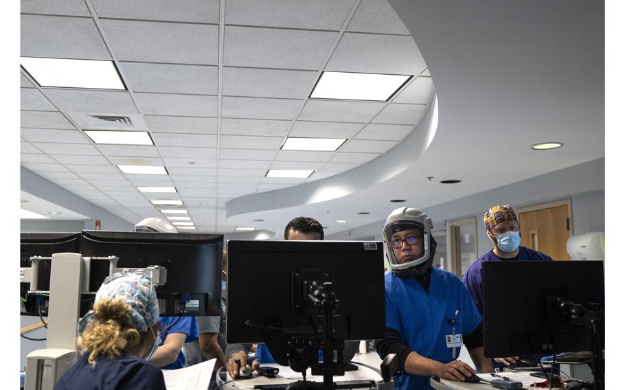 Doctors and other medical staffers make rounds in the ICU at Luminis Health Doctors Community Hospital in Lanham, Md., on Jan. 14, 2022. 