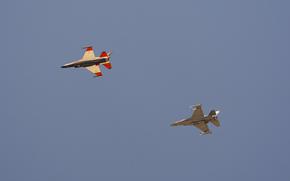 An AI-enabled Air Force F-16 fighter jet, left, flies next to an adversary F-16, as both aircraft race within 1,000 feet of each other, trying to force their opponent into vulnerable positions, on Thursday, May 2, 2024, above Edwards Air Force Base, Calif. The flight is serving as a public statement of confidence in the future role of AI in air combat. The military is planning to use the technology to operate an unmanned fleet of 1,000 aircraft. (AP Photo/Damian Dovarganes)