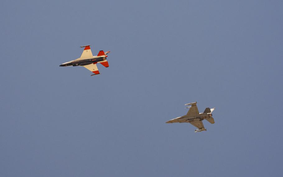 Two fighter jets in the sky, as seen from the ground, at slightly different angles.