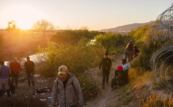 A group of migrants rest after crossing the US-Mexico border through the Rio Grande in El Paso, Texas, on Wednesday, April 3, 2024. MUST CREDIT: Justin Hamel/Bloomberg