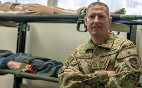 U.S Air Force Capt. Joshua Haveman, 60th Air Evacuation Squadron flight instructor, stands in front of litters and training mannequins at Travis Air Force Base, California, Sept. 23, 2023. Haveman was involved in the rescue of a climber on Half Dome at Yosemite National Park, California, Sep. 2, 2023. (U.S. Air Force Photo by Senior Airman Lauren Jacoby)