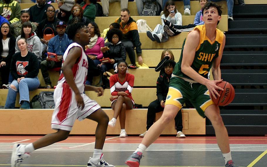 Bela Clobes von SHAPE beobachtet den Korb, während Kaiserslauterns Dom Polider versucht, Freitagabend in der Kaiserslautern High School in Kaiserslautern, Deutschland, zu verteidigen.  Die Spartaner schlagen die Raiders mit 48:40.