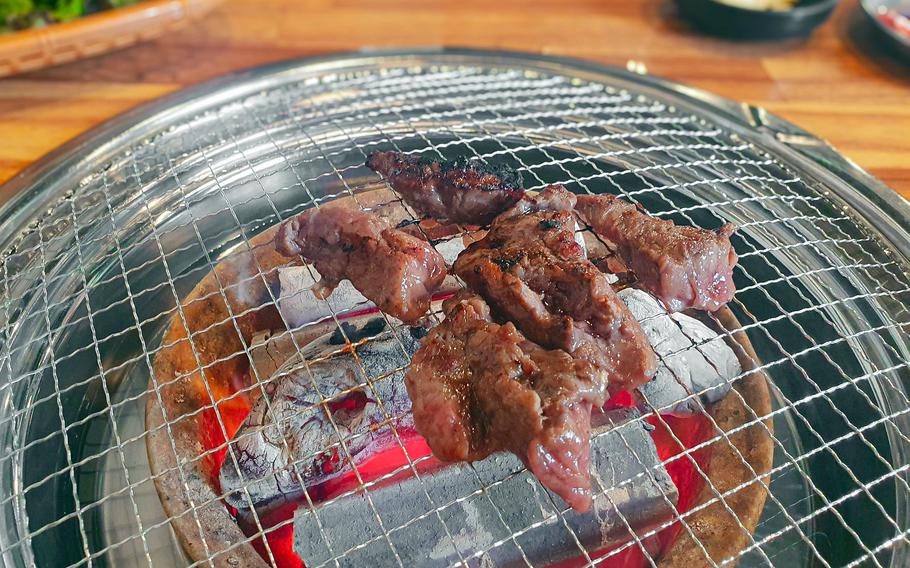 Marinated steak sizzles on the grill at Sododuk near Camp Humphreys, South Korea.