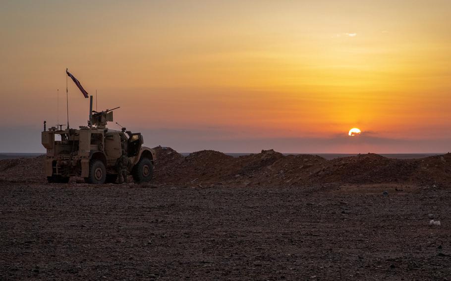 A Joint Light Tactical Vehicle set up a perimeter in Syria as the sun sets in the background.
