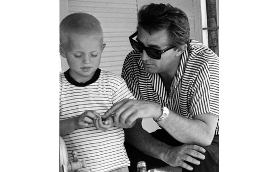 Lloyd Borguss/Stars and Stripes
Athens, Greece, June, 1958: Five-year-old Glenn Ross, son of Sfc. Bill Ross from the finance section of the Joint US Military Advisory Group, talks with Robert Mitchum after asking for an autograph. The actor was in Athens to film "The Angry Hills," a story about Greek resistance during World War II.