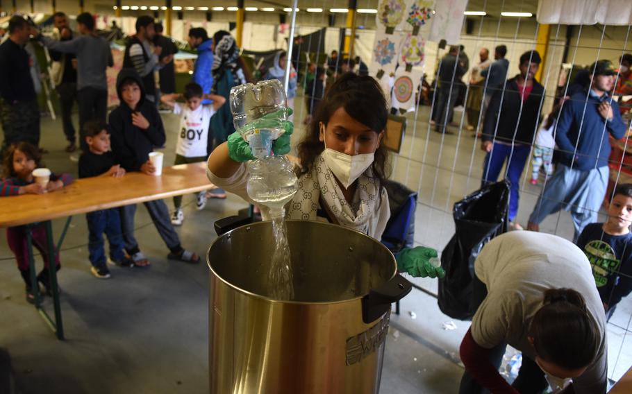 Madina Fahim, 15, fills a tank with bottled water to be heated for formula and tea at Rhine Ordnance Barracks, Germany, on Monday, Sept. 20, 2021. She practices her English while helping American volunteers take requests for formula and tea at the temporary living area for Afghan evacuees at ROB.