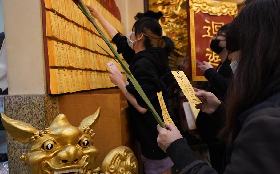 Worshippers pick their divine poems to find their oracles corresponding with the number for the year during the lunar New Year celebrations at the Thien Hau Temple in the Chinatown neighborhood of Los Angeles early Tuesday, Feb. 1, 2022. The celebration marks the Year of the Tiger in the Chinese Zodiac calendar. 